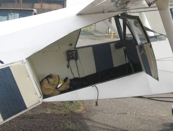 View into the rear storage area of the aircraft, showing the interior walls and a bag.