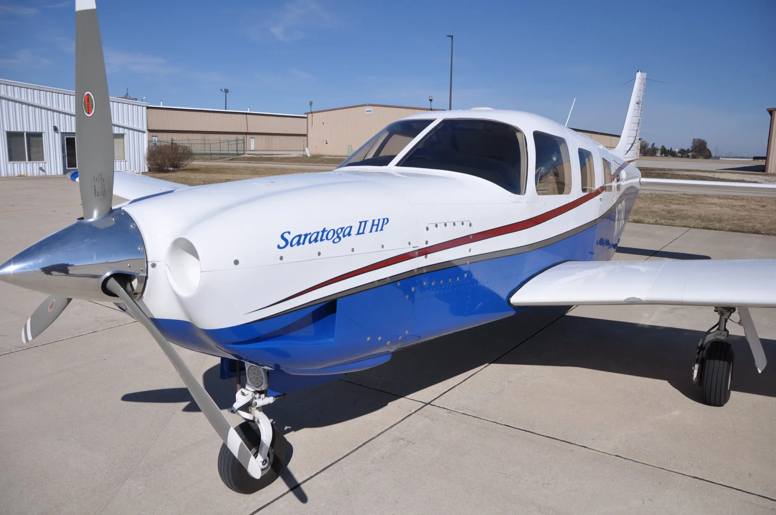 Close up of the front of a Saratoga II HP aircraft with a blue and white paint scheme.