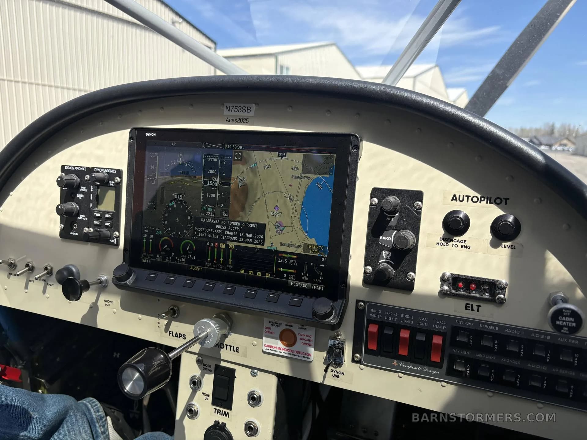 A close-up of the cockpit instrument panel of a light aircraft, featuring a large Dynon SkyView display and various switches.