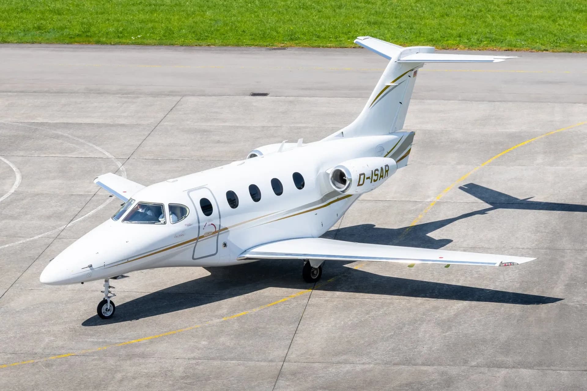A white jet with gold trim sits on the tarmac.