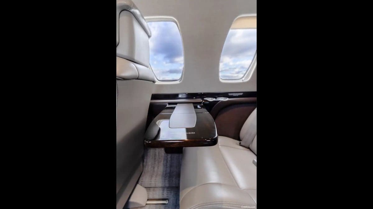 Close-up of the aircraft's interior cabin showing a leather seat and fold-out table.