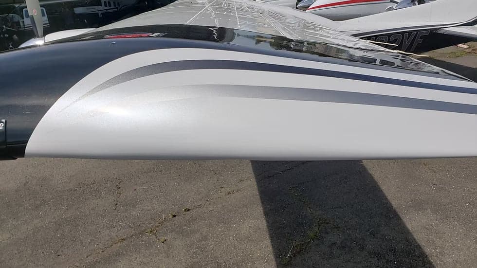 Close up of the wing of a black and white Cessna 208B Grand Caravan, registration N22VF.