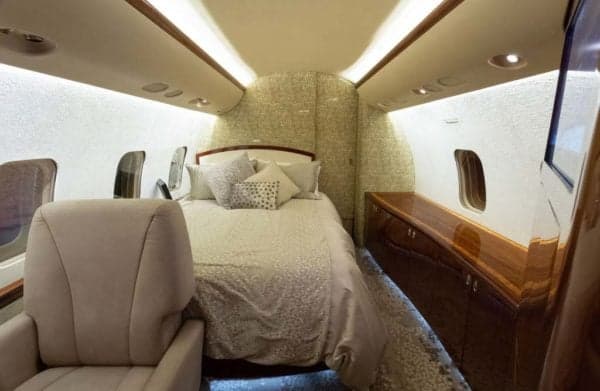 The interior of the Bombardier Challenger 300 features a comfortable bed and luxurious amenities.