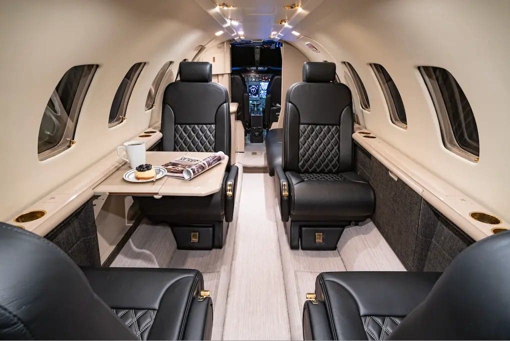 View of the interior cabin of the Cessna Citation Ultra, showing the seating arrangement and table.