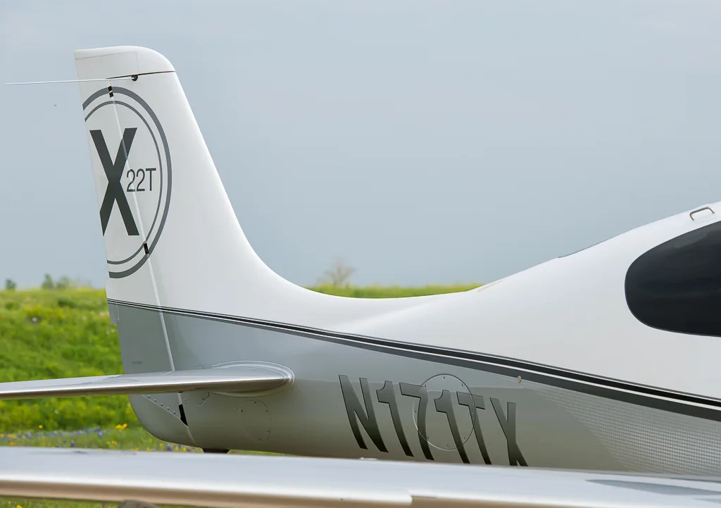 A close-up view of the tail section of the Cirrus SR22T N171TX, showing the registration number and a '22T X' logo on the vertical stabilizer.