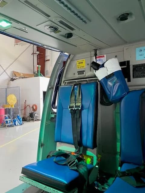 Interior view of the helicopter cabin with blue seats.