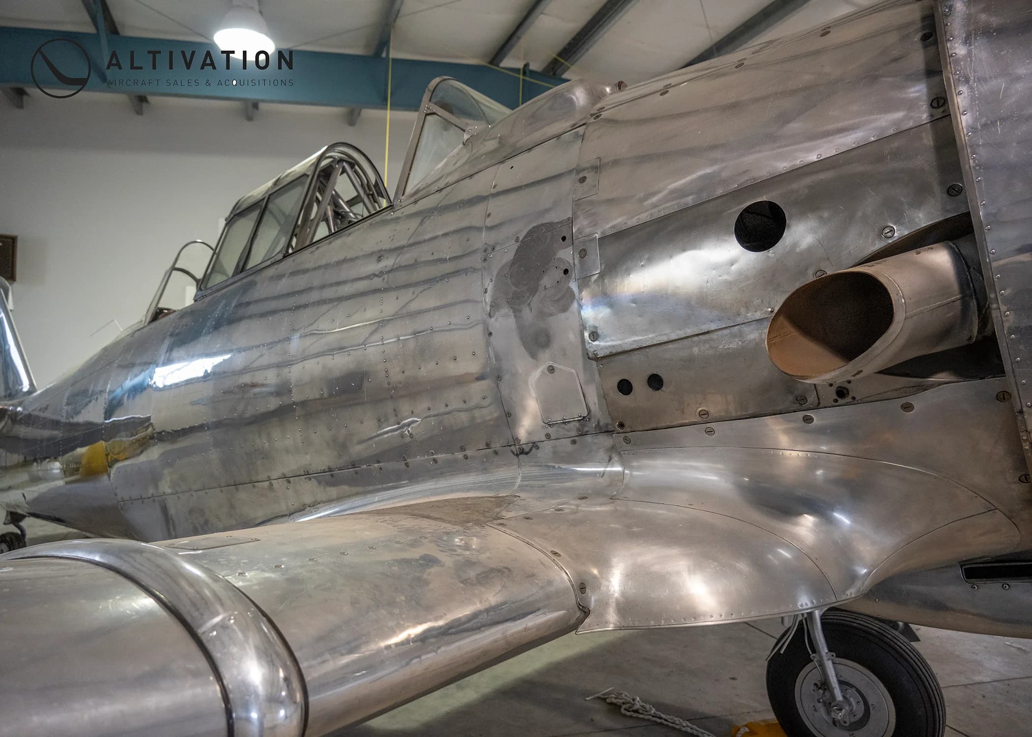 Close up of the side of a silver aircraft.