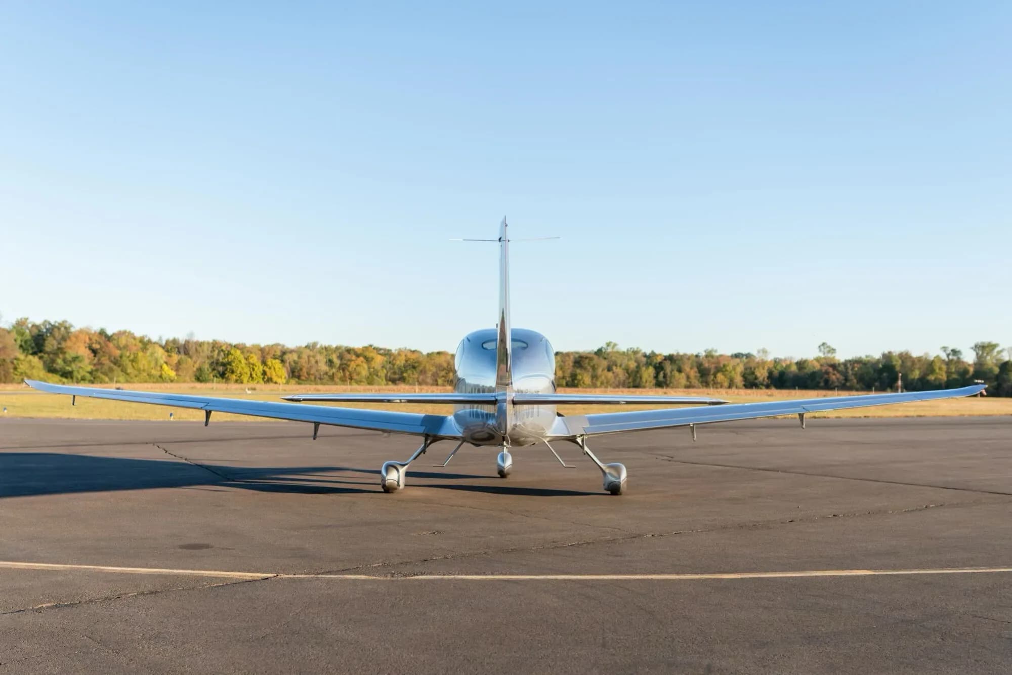 A rear view of the silver and grey Cirrus SR22 aircraft (N285WT) parked on an asphalt tarmac.