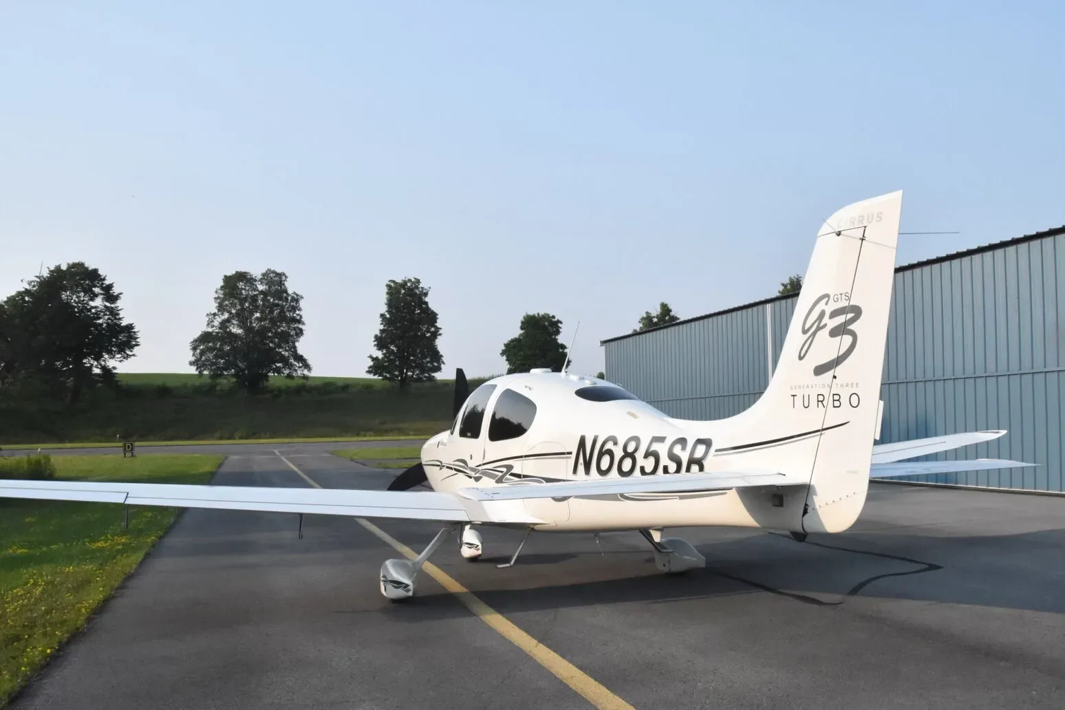 Rear-side view of the white Cirrus SR22 G3 Turbo aircraft (N685SR) on the tarmac.
