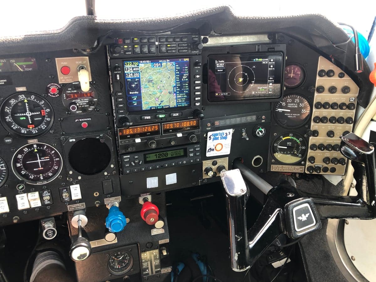 Wide view of the aircraft's cockpit instrument panel and avionics.