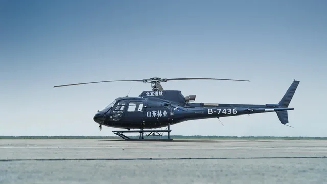 A dark blue helicopter with registration B-7436 parked on an airfield, viewed from the side.