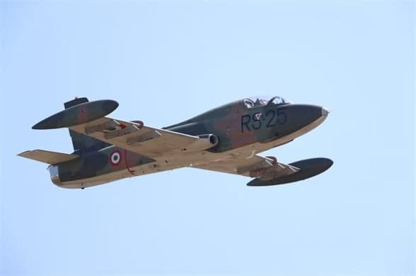 Camouflaged aircraft I-MBCK in flight against a blue sky.