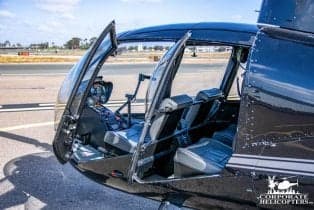 Interior view of the Robinson R44 helicopter with open doors.