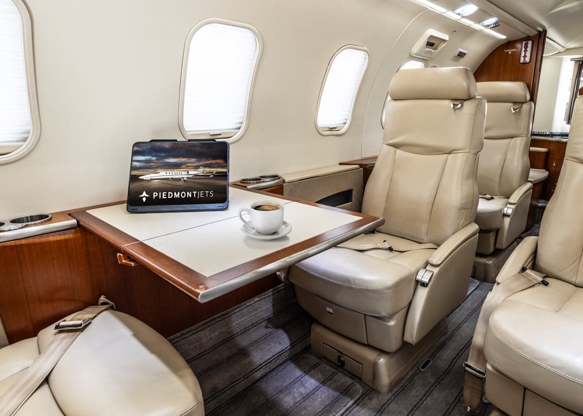 View of the interior cabin of a Learjet 45XR aircraft with a table and tablet.