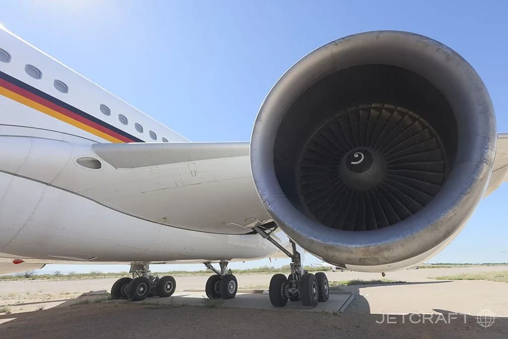 A low-angle close-up of an engine and the main landing gear of an Airbus A340-300.