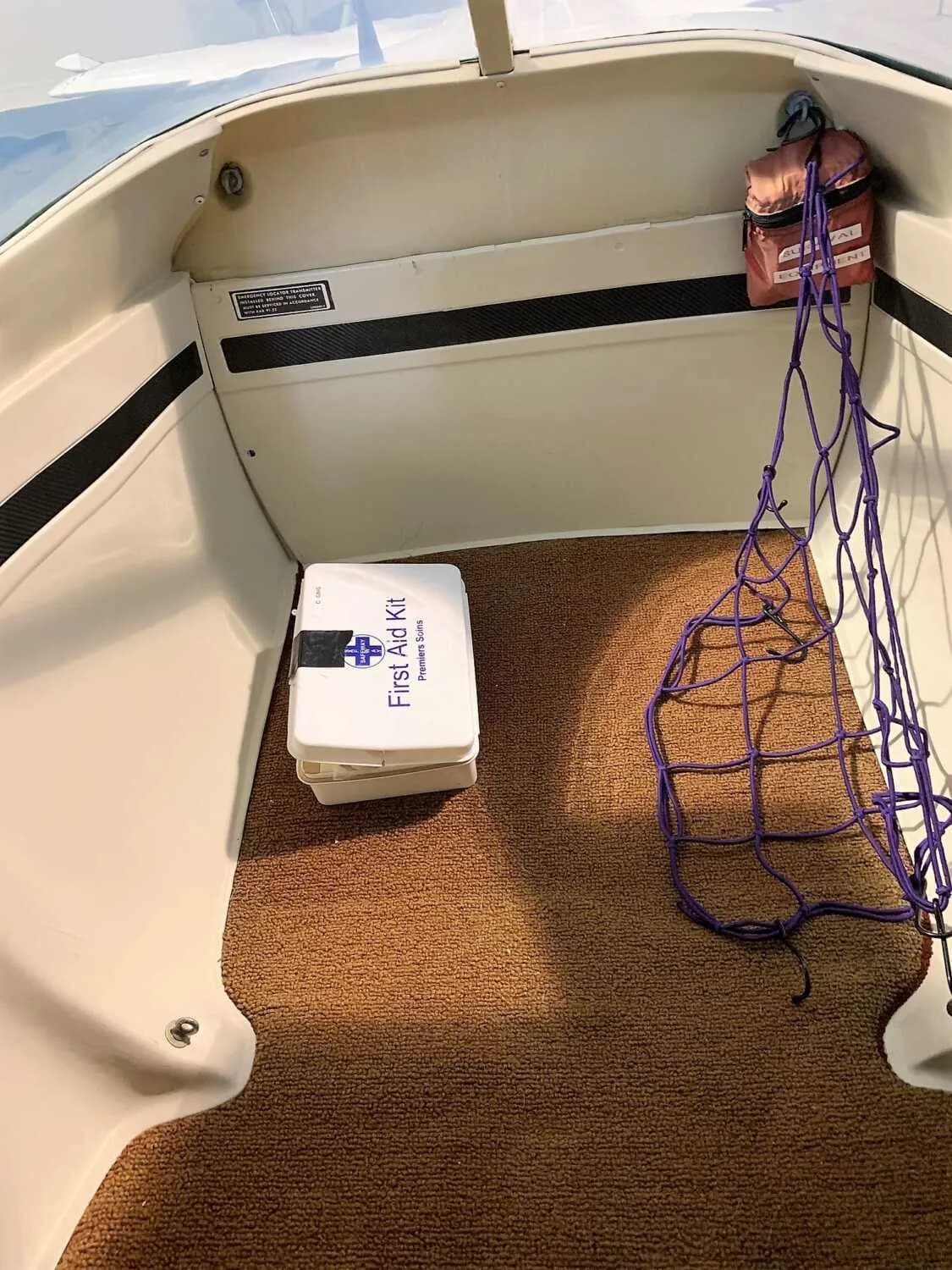 Rear baggage area of a Cessna 172 Skyhawk with a first aid kit.