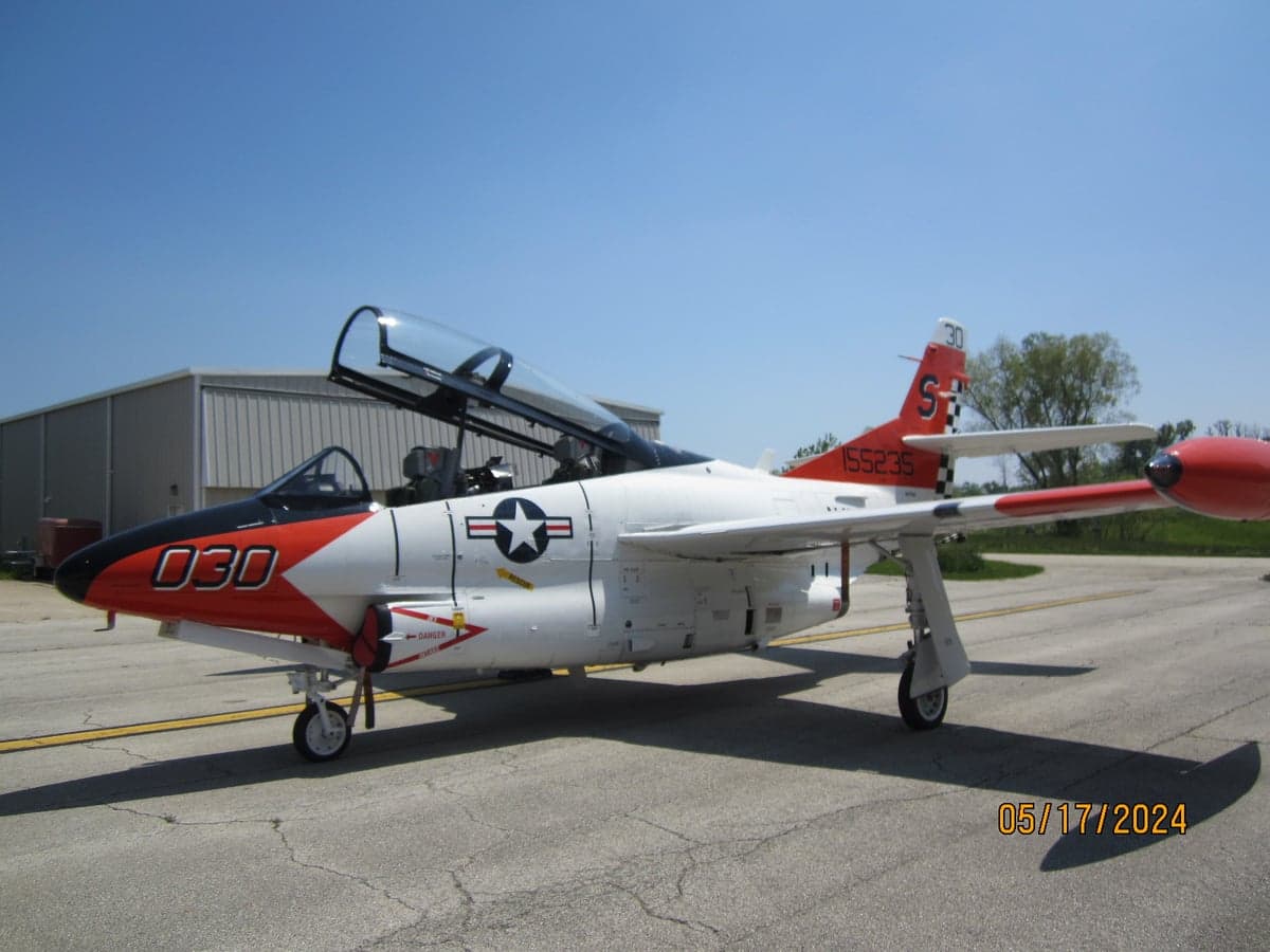 A T-2B Buckeye aircraft parked on the tarmac with the canopy open.