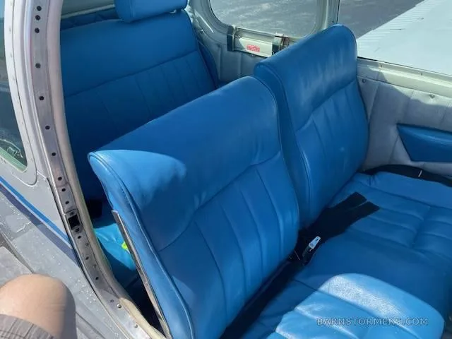 The aircraft's interior cabin with two rows of bright blue vinyl seats.