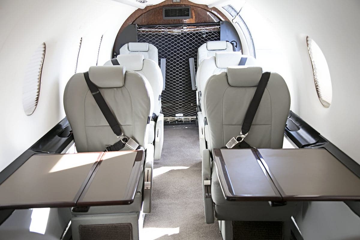 View of the interior cabin seating and tables of the Pilatus PC-12 aircraft.