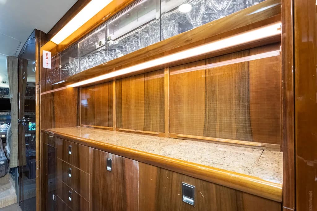 A wood-paneled bar area is visible in the aircraft's interior.
