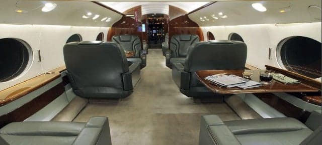 The aircraft's interior features leather seats and wood paneling.
