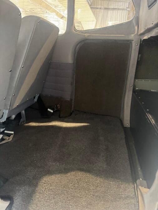 View of the carpeted floor and rear seats inside the aircraft cabin.