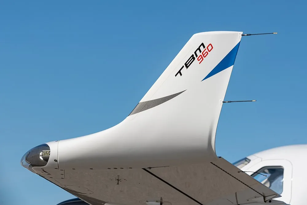 A close-up view of the white and blue tail of the TBM 960 aircraft.