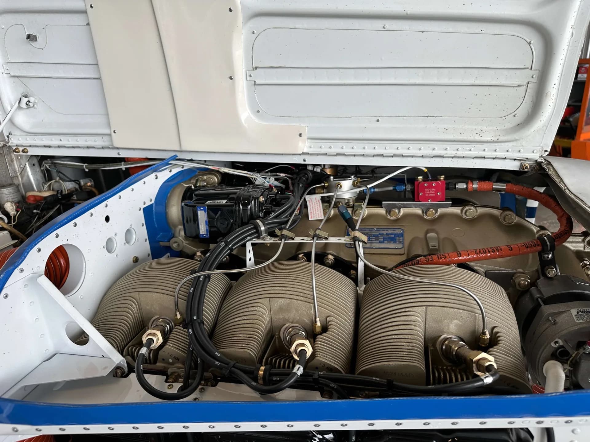 A close-up view of the engine cylinders and components of a Beechcraft Bonanza with the cowling open.
