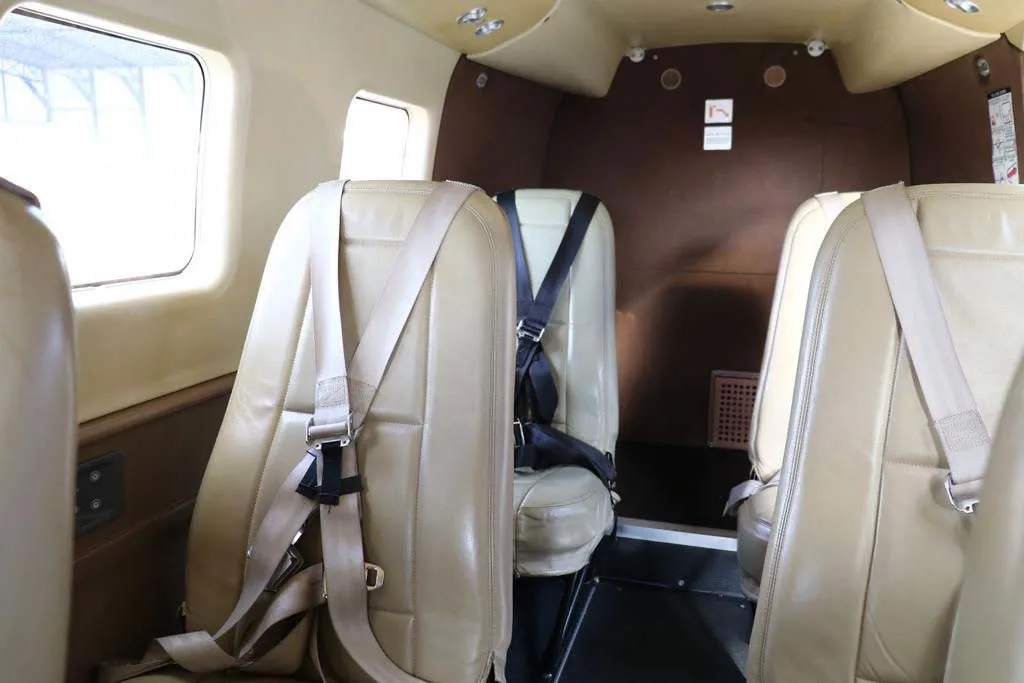 A close-up view of the light tan leather passenger seats in the aircraft's cabin.
