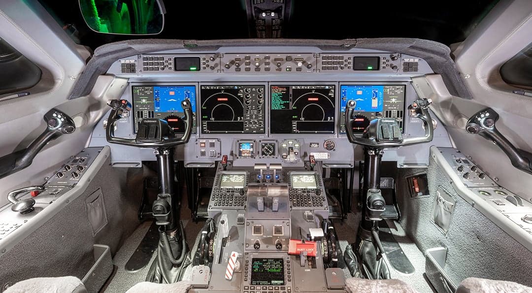 The cockpit of the aircraft features multiple display screens and control panels.