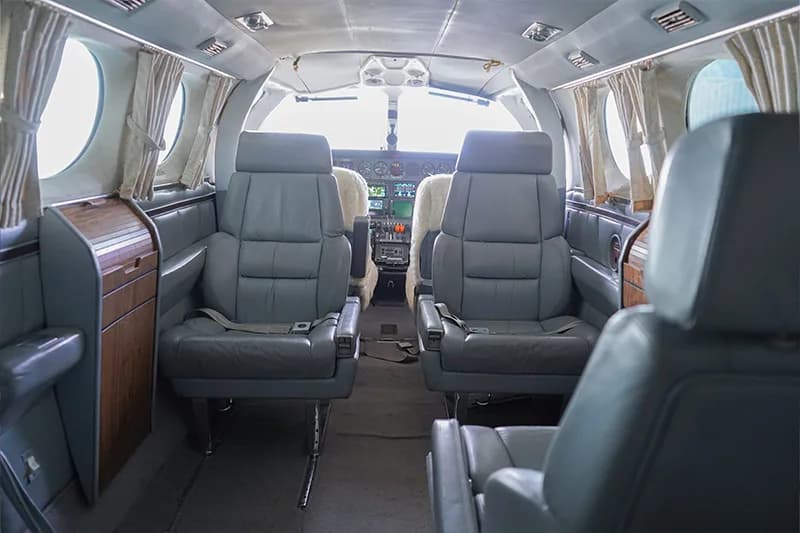 The interior of a Cessna 421 Golden Eagle aircraft features leather seats and wood trim.