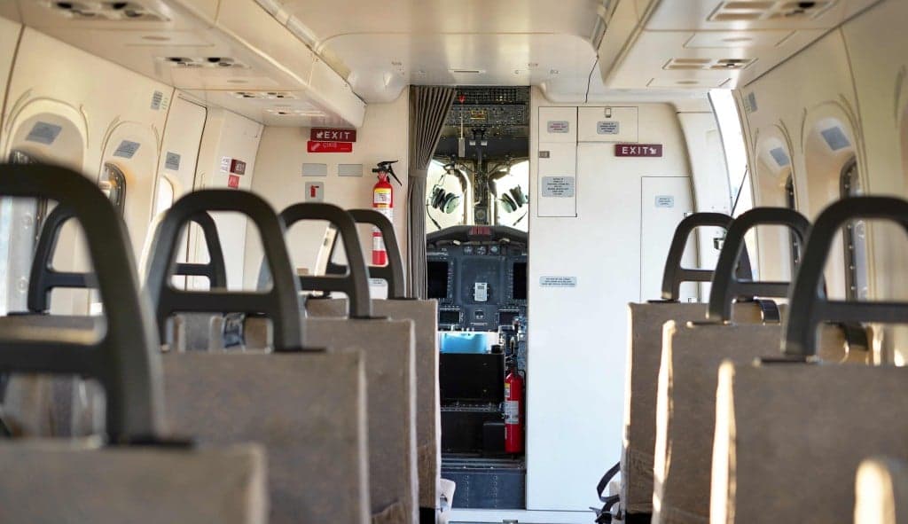 The interior of an aircraft cabin with rows of seats.