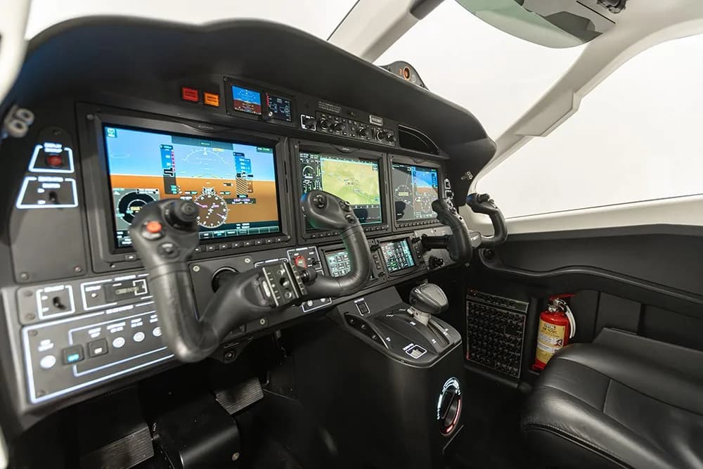 A view of the TBM 960 cockpit with multiple Garmin display screens and flight controls.