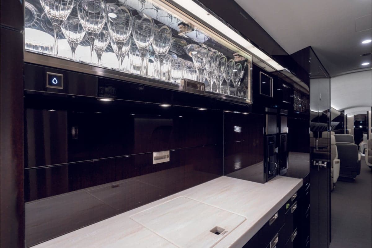 Bombardier aircraft interior with a bar and glassware.