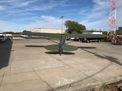 Front view of an olive drab aircraft on the ramp.