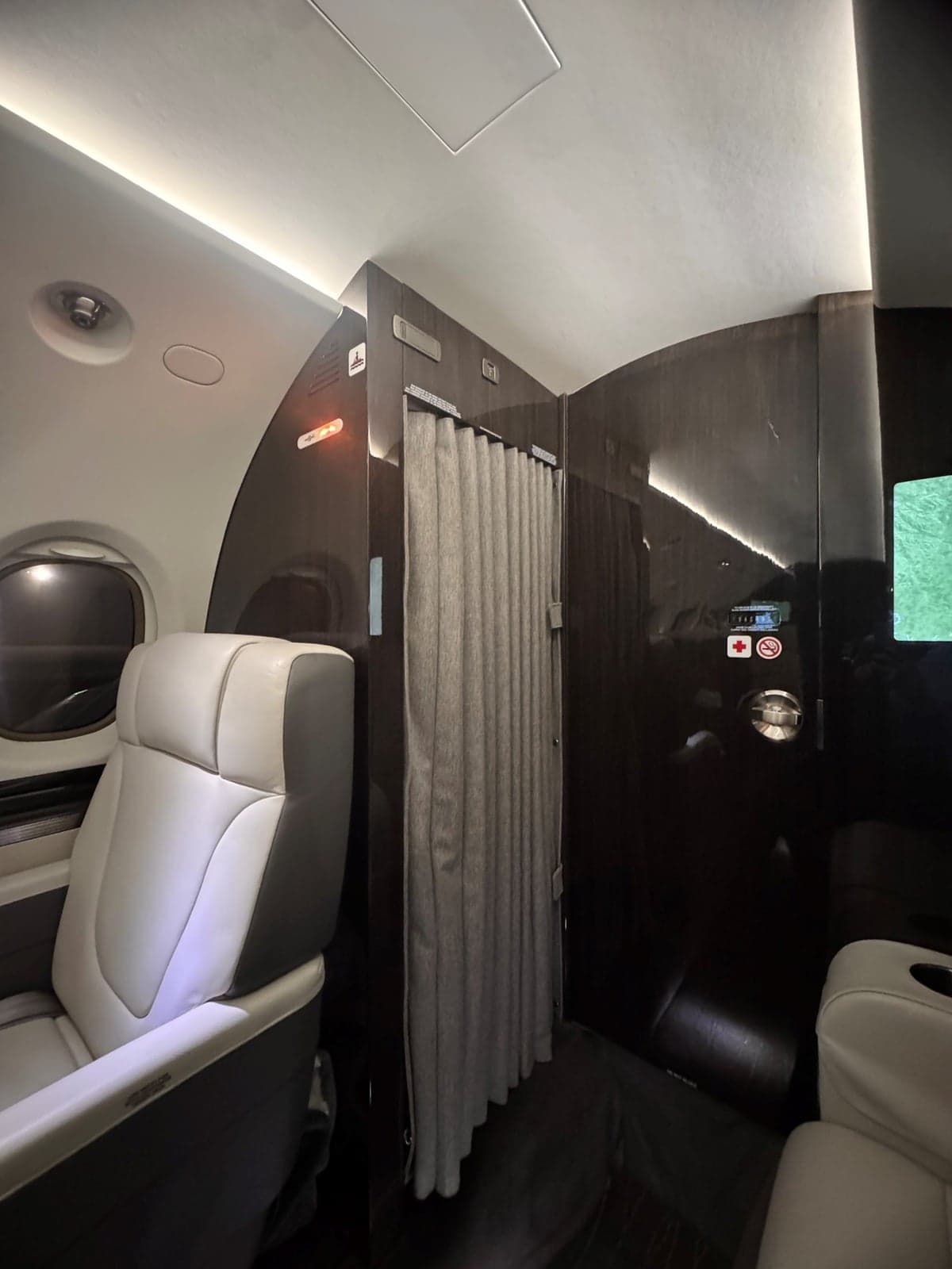View of the aircraft's interior showing a seat and a curtained-off area.