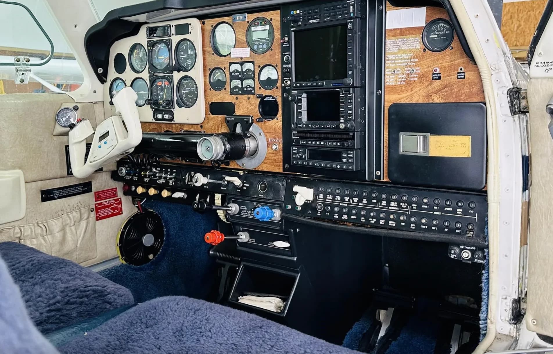 A close-up view of the Beechcraft Bonanza N7SP cockpit instrument panel with modern avionics and wooden trim.