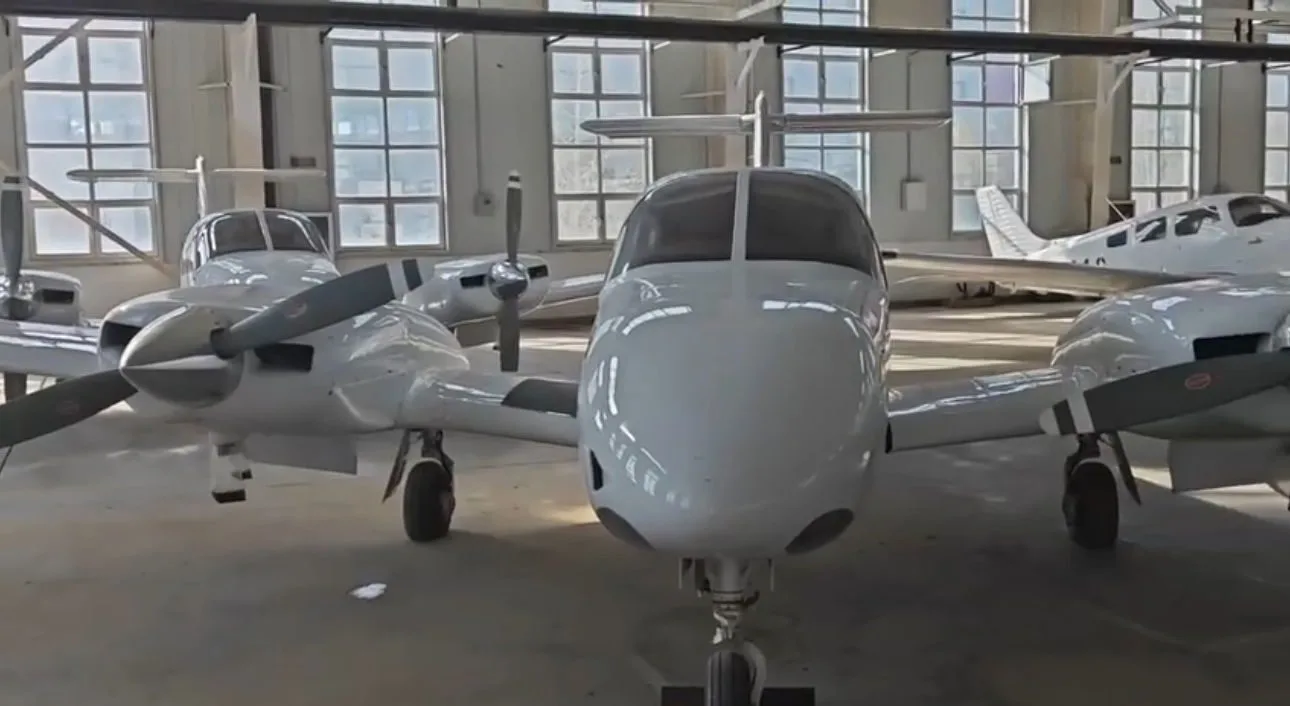 Close-up of a white twin-engine aircraft in a hangar.