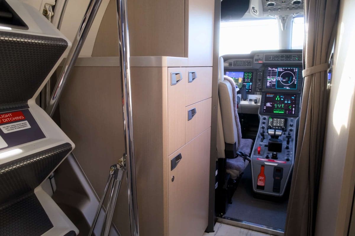 View of the aircraft's interior cabin with stairs and a view into the cockpit.