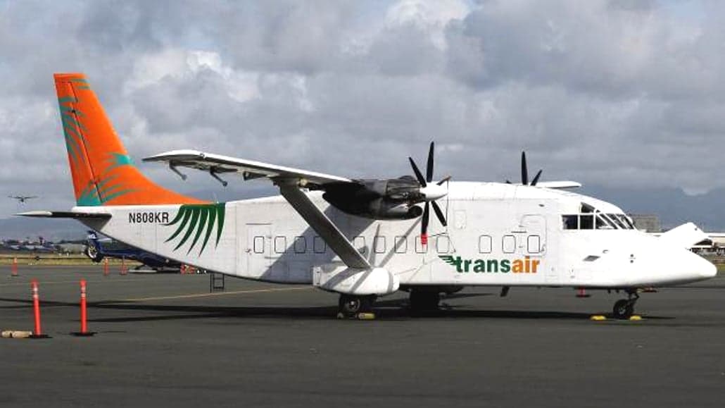 Side view of a white and orange Short 360 aircraft with 'transair' livery.