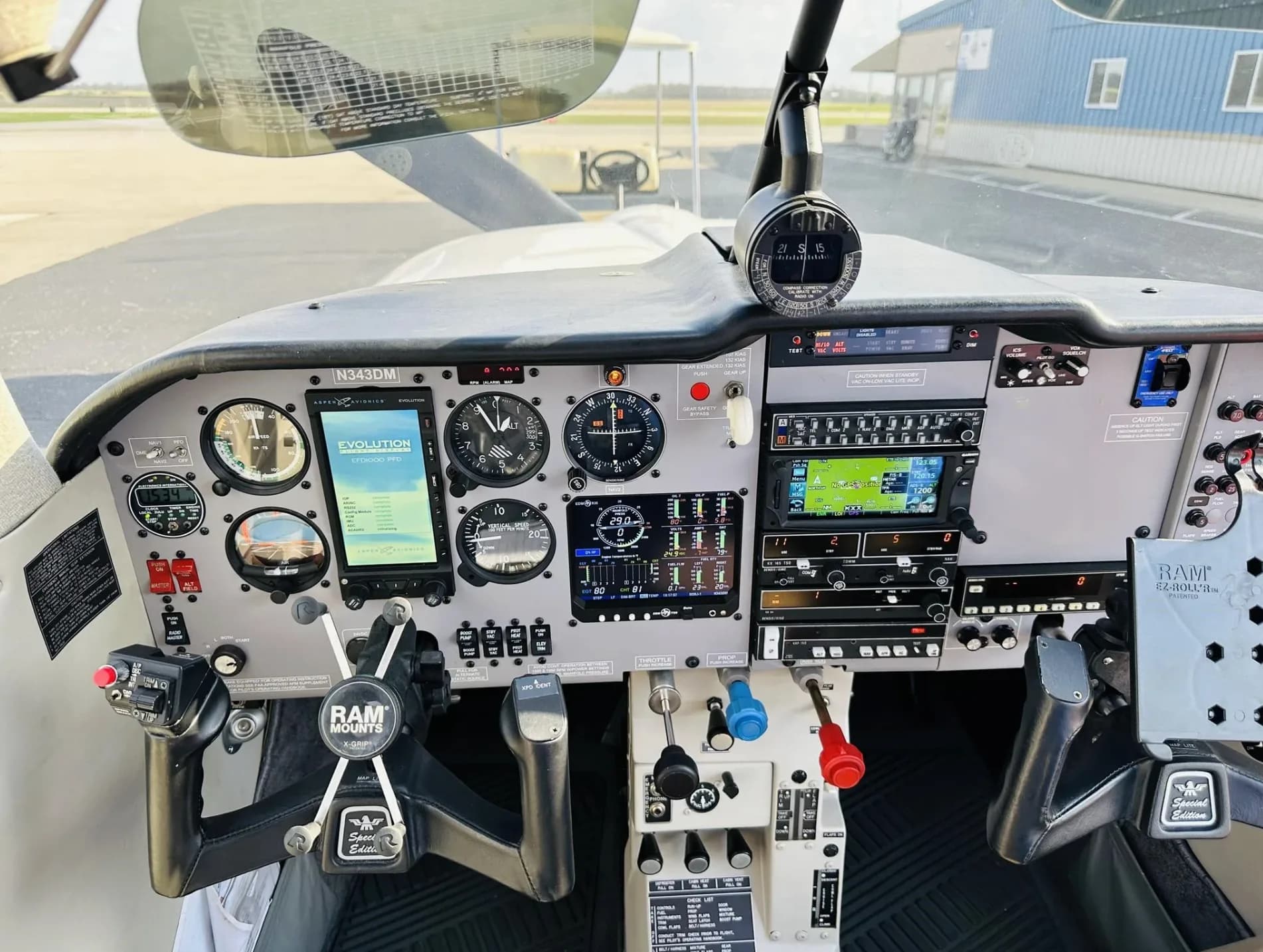 A wide view of the Mooney aircraft cockpit, showing the complete instrument panel, yokes, and pedals.