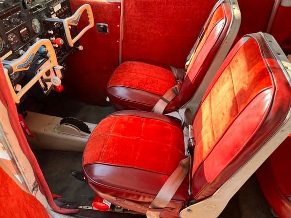 Red interior of the Cessna 210, showing the seats and control yoke.