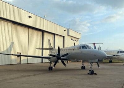 A Metro aircraft parked in front of a hangar.