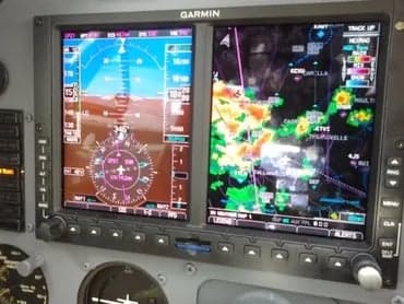A Garmin display in the cockpit of a Cessna 421C Golden Eagle aircraft showing navigation and weather information.