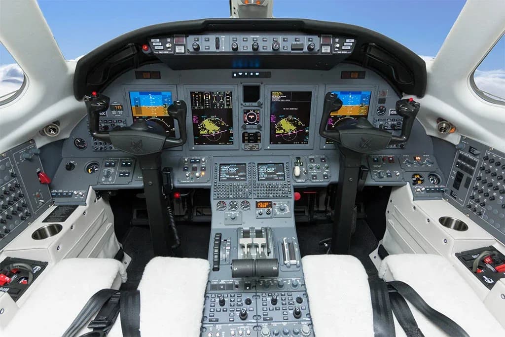 The cockpit of a Citation XLS+ aircraft, featuring multiple digital displays and a complex control panel.