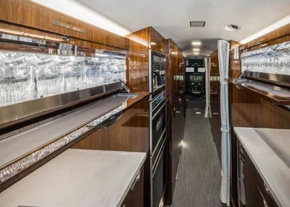 Galley area of the aircraft interior with wood cabinetry and appliances.