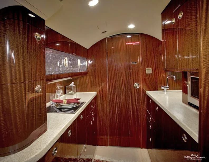 The aircraft's galley features wood cabinetry and countertops.