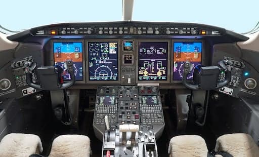Close up of the Challenger 300 cabin table with a pen, glasses, and notebook.