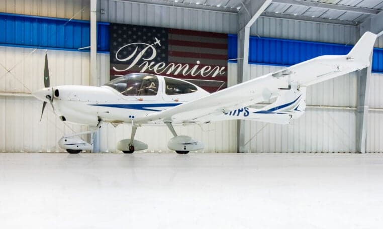 A Diamond DA40 aircraft with registration N317PS is parked in a hangar.