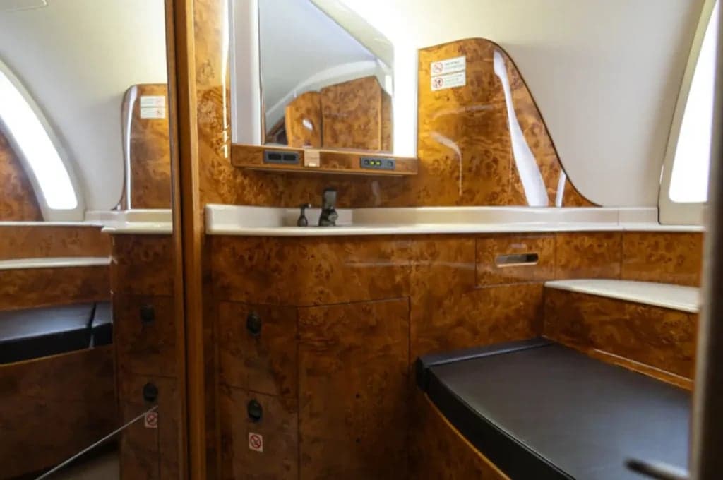 View of the lavatory with wood accents and a mirror.